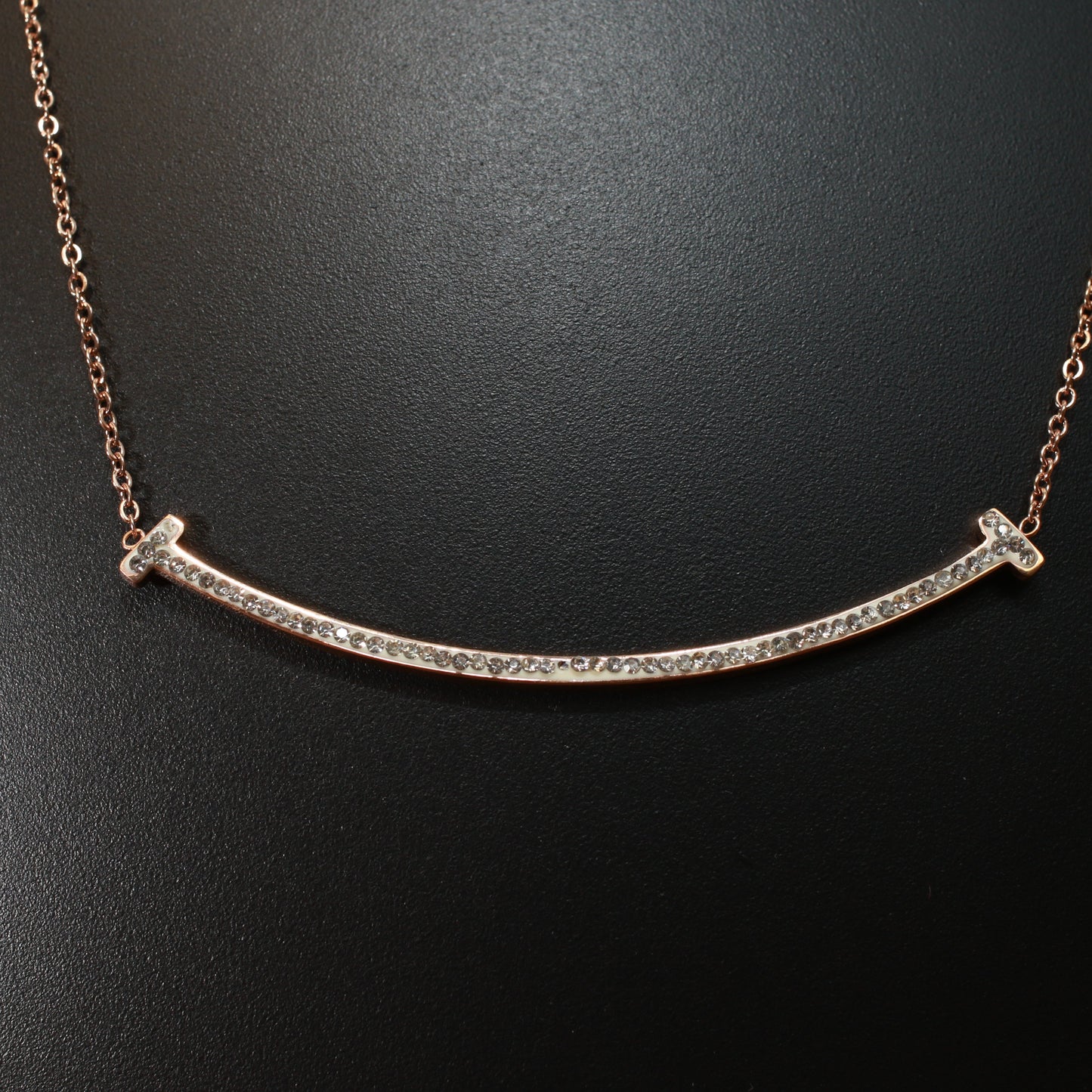 Curved bar covered in rhinestones, rose-gold chain
