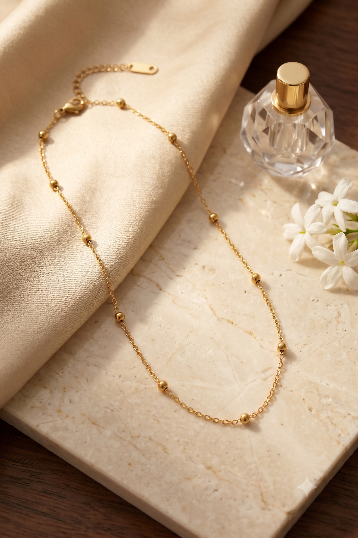 Dainty gold bead station chain necklace, 18K gold plated – styled on jewelry stand