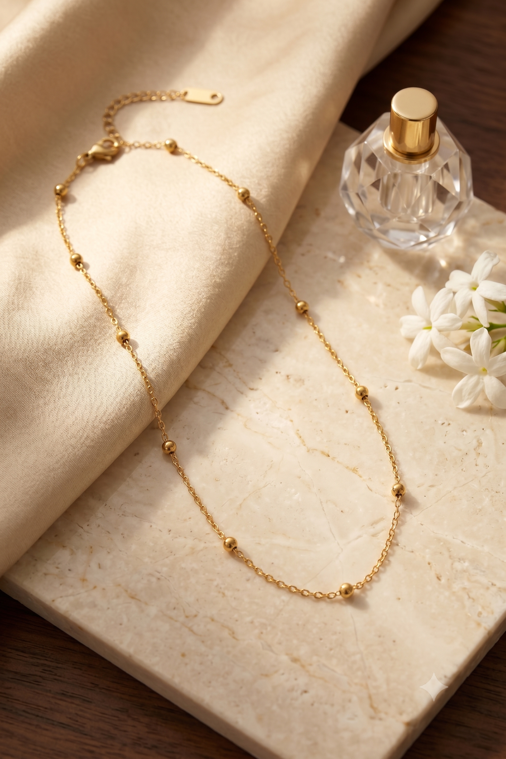 Dainty gold bead station chain necklace, 18K gold plated – styled on jewelry stand